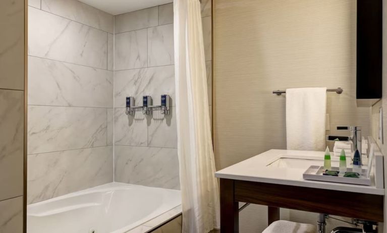 Private guest bathroom with tub and free toiletries at the Four Points By Sheraton St Catharines Niagara Suites.