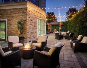 Outdoor patio with lounge seating and fireplace  at Staybridge Suites Oakville-Burlington.