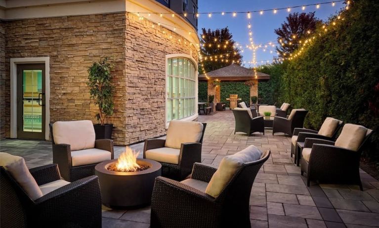 Outdoor patio with lounge seating and fireplace  at Staybridge Suites Oakville-Burlington.