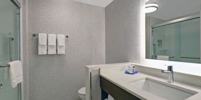 Private guest bathroom with shower and free toiletries at Holiday Inn Express Kingston West.