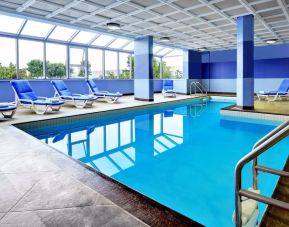 Relaxing indoor pool with lounge chairs at Four Points By Sheraton Toronto Mississauga.