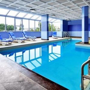 Relaxing indoor pool with lounge chairs at Four Points By Sheraton Toronto Mississauga.