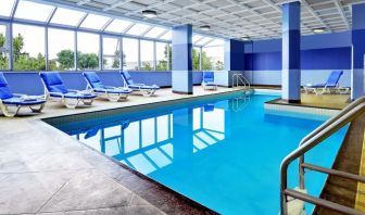 Relaxing indoor pool with lounge chairs at Four Points By Sheraton Toronto Mississauga.