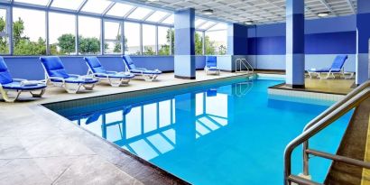 Relaxing indoor pool with lounge chairs at Four Points By Sheraton Toronto Mississauga.