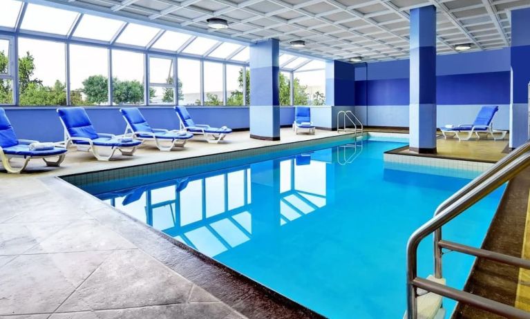 Relaxing indoor pool with lounge chairs at Four Points By Sheraton Toronto Mississauga.