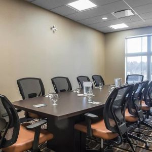 Professional meeting room with large windows and ergonomic chairs at Quality Inn & Suites Kingston.