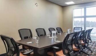 Professional meeting room with large windows and ergonomic chairs at Quality Inn & Suites Kingston.