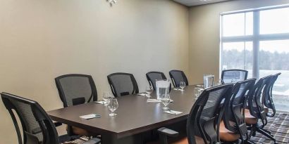 Professional meeting room with large windows and ergonomic chairs at Quality Inn & Suites Kingston.