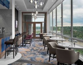 Bar lounge with large windows and comfortable chairs at Courtyard By Marriott Edmonton Downtown.