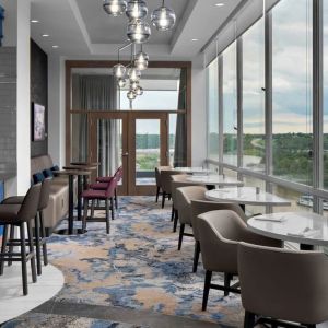 Bar lounge with large windows and comfortable chairs at Courtyard By Marriott Edmonton Downtown.