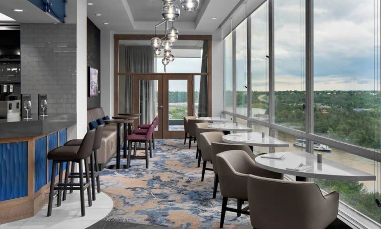 Bar lounge with large windows and comfortable chairs at Courtyard By Marriott Edmonton Downtown.