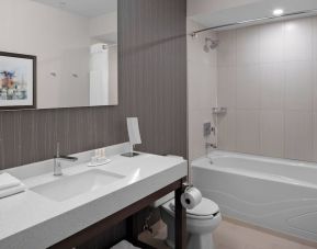 Private guest bathroom with tub and free toiletries at Courtyard By Marriott Edmonton Downtown.