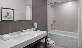 Private guest bathroom with tub and free toiletries at Courtyard By Marriott Edmonton Downtown.