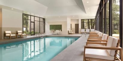 Relaxing indoor pool with lounge chairs at DoubleTree By Hilton Hotel Toronto Airport West.