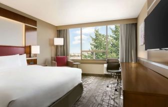 Day use room with large windows, TV, sofa, work desk and private bathroom at DoubleTree By Hilton Hotel Toronto Airport West.