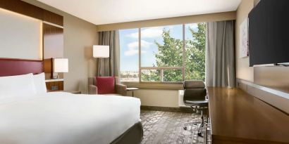 Day use room with large windows, TV, sofa, work desk and private bathroom at DoubleTree By Hilton Hotel Toronto Airport West.