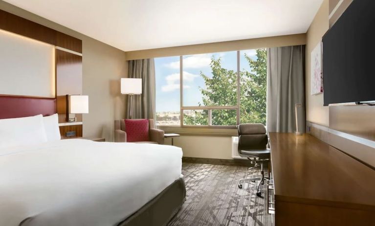 Day use room with large windows, TV, sofa, work desk and private bathroom at DoubleTree By Hilton Hotel Toronto Airport West.