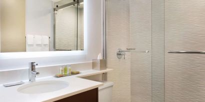 Private guest bathroom with shower and free toiletries at DoubleTree By Hilton Hotel Toronto Airport West.