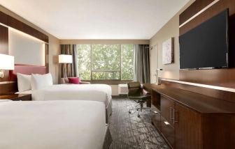 Day use twin room with large windows, TV, sofa, work desk and private bathroom at DoubleTree By Hilton Hotel Toronto Airport West.