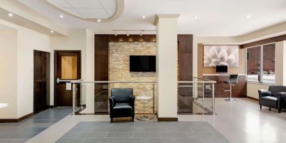 Hotel lobby with lounge area and workspace at La Quinta Inn & Suites By Wyndham Oshawa.