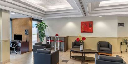 Hotel lobby with lounge area and work station at Quality Hotel & Suites Montreal East.