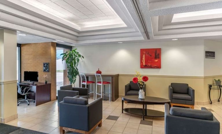 Hotel lobby with lounge area and work station at Quality Hotel & Suites Montreal East.