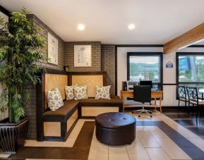 Hotel lobby with lounge area and workspace with computer and printer at Days Inn Vernon.