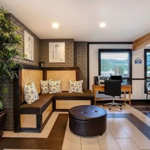 Hotel lobby with lounge area and workspace with computer and printer at Days Inn Vernon.