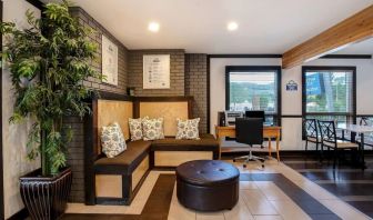 Hotel lobby with lounge area and workspace with computer and printer at Days Inn Vernon.