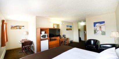 Day use room with TV, tables, sofas, mini bar, microwave and private bathroom at Riviera Motor Inn.