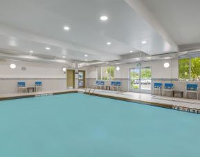 Relaxing indoor pool with lounge chairs at Days Inn & Suites By Wyndham Lindsay.