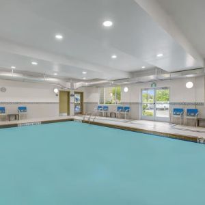 Relaxing indoor pool with lounge chairs at Days Inn & Suites By Wyndham Lindsay.