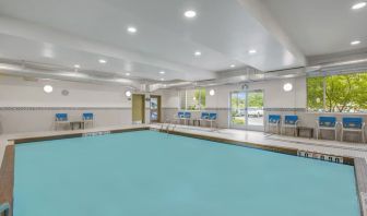 Relaxing indoor pool with lounge chairs at Days Inn & Suites By Wyndham Lindsay.