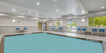 Relaxing indoor pool with lounge chairs at Days Inn & Suites By Wyndham Lindsay.