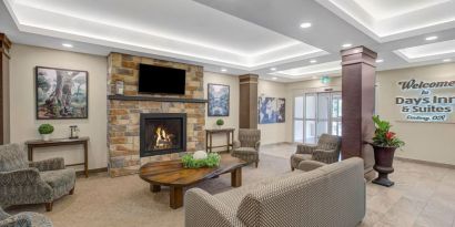 Lobby lounge area with fireplace at Days Inn & Suites By Wyndham Lindsay.