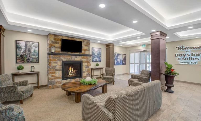 Lobby lounge area with fireplace at Days Inn & Suites By Wyndham Lindsay.