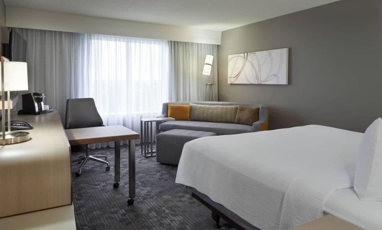 Bright day use room with TV, sofa, work desk and private bathroom at Courtyard By Marriott Toronto Airport.