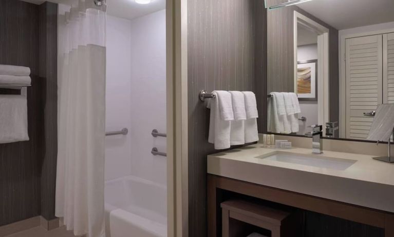 Private guest bathroom with tub and free toiletries at Courtyard By Marriott Toronto Airport.