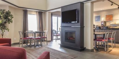 Lobby lounge with fireplace at Comfort Inn Sept-Iles. 