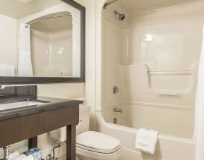 Guest bathroom with tub and free toiletries at Comfort Inn Sept-Iles. 