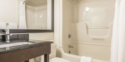 Guest bathroom with tub and free toiletries at Comfort Inn Sept-Iles. 