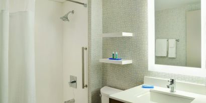 Private guest bathroom with shower and tub at Holiday Inn Express Toronto Downtown.