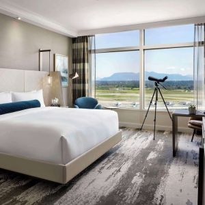 Day use room with large window, sofa, work desk and private bathroom at Fairmont Vancouver Airport - YVR Terminal Hotel.