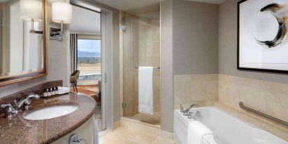 Private guest bathroom with shower and tub at Fairmont Vancouver Airport - YVR Terminal Hotel.