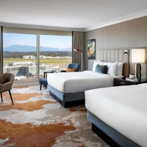 Bright and spacious day use twin room with TV, sofa, work desk and private bathroom at Fairmont Vancouver Airport - YVR Terminal Hotel.