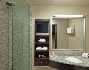 Guest bathroom with shower and free toiletries at Acclaim Hotel Calgary Airport.