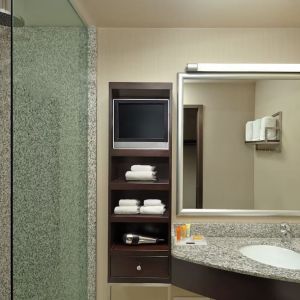 Guest bathroom with shower and free toiletries at Acclaim Hotel Calgary Airport.