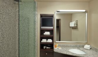 Guest bathroom with shower and free toiletries at Acclaim Hotel Calgary Airport.