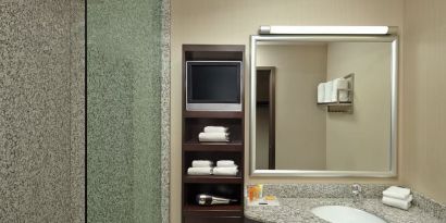 Guest bathroom with shower and free toiletries at Acclaim Hotel Calgary Airport.