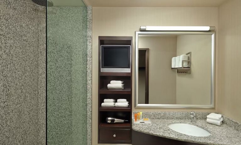 Guest bathroom with shower and free toiletries at Acclaim Hotel Calgary Airport.